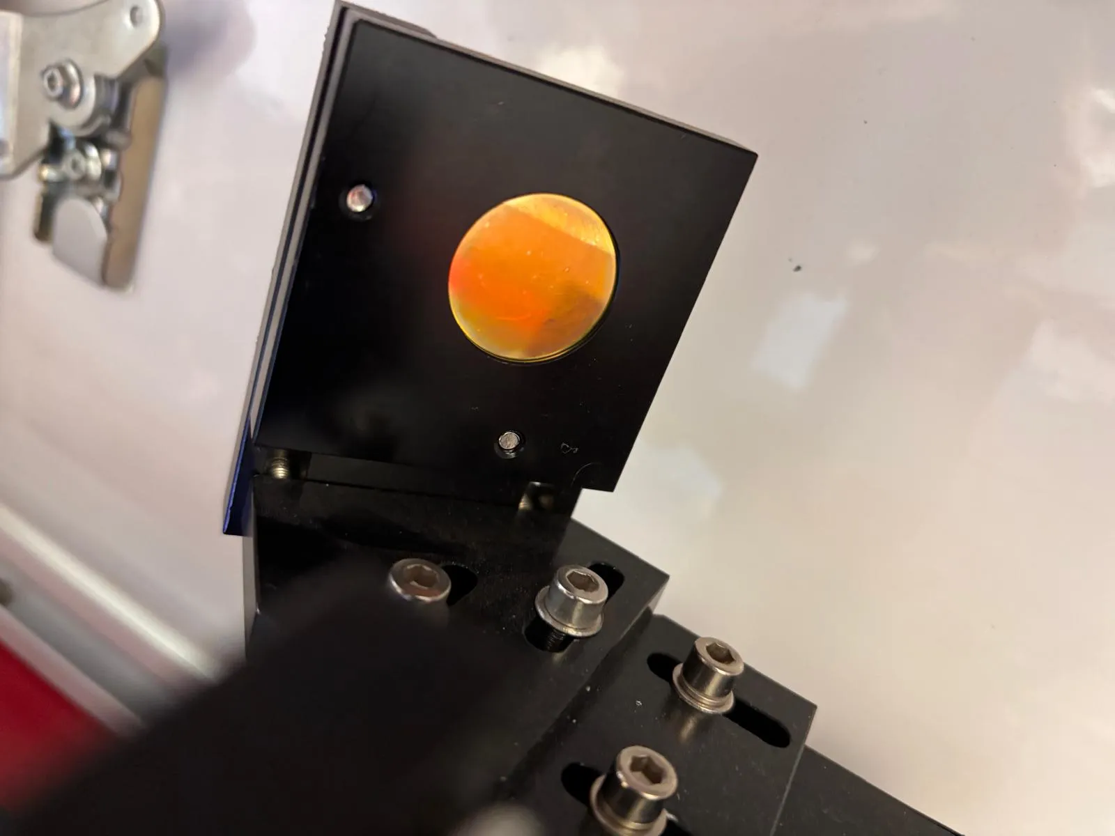 Goldbeschichtete Fokusoptik eines Lasers in der Halterung waehrend der Inspektion